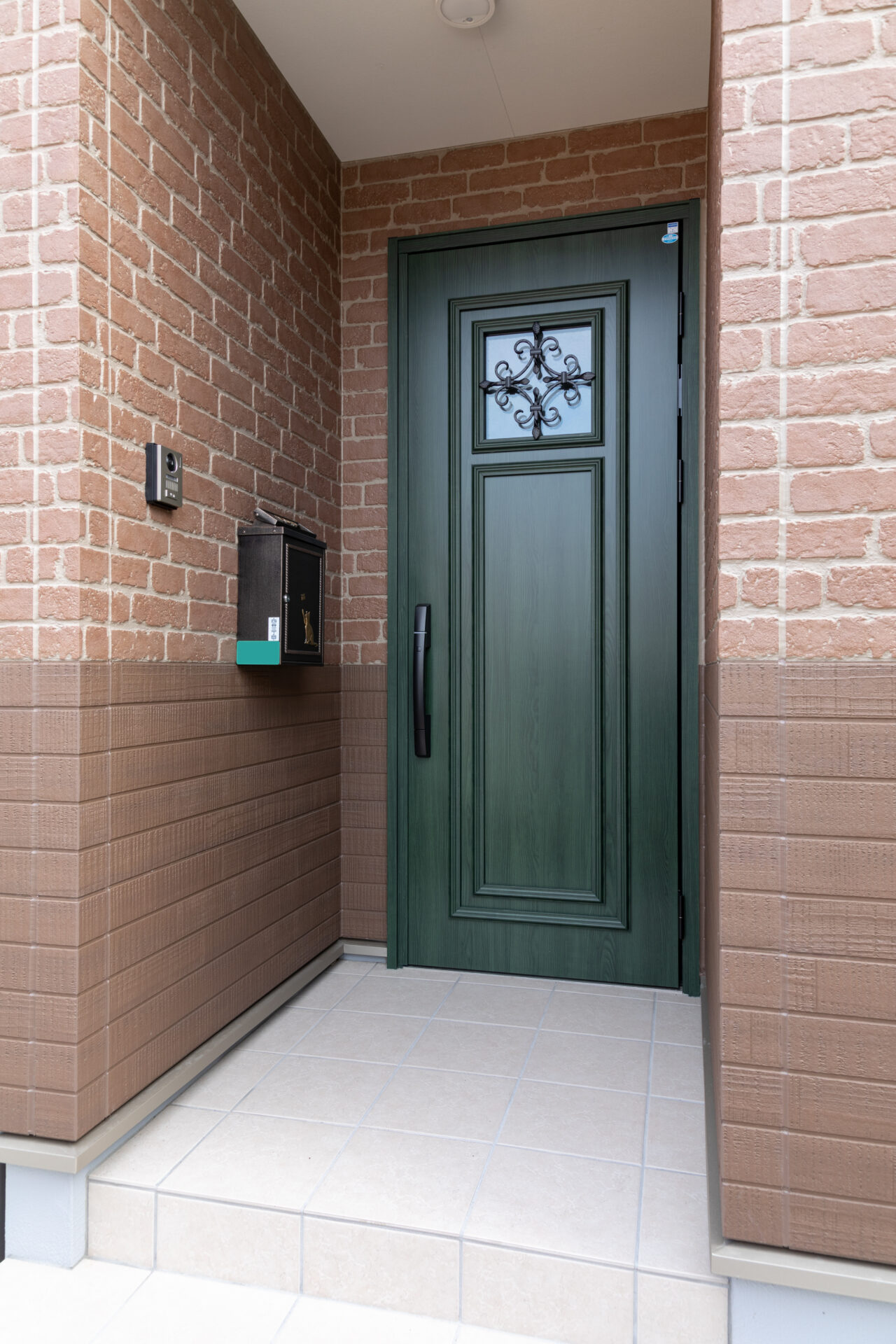 玄関ドアは木目が美しいグリーンをチョイス。外観に高級感を与えている